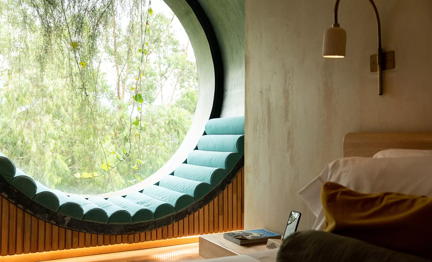 1. Ventana redonda en un dormitorio con una cama y una silla al lado.