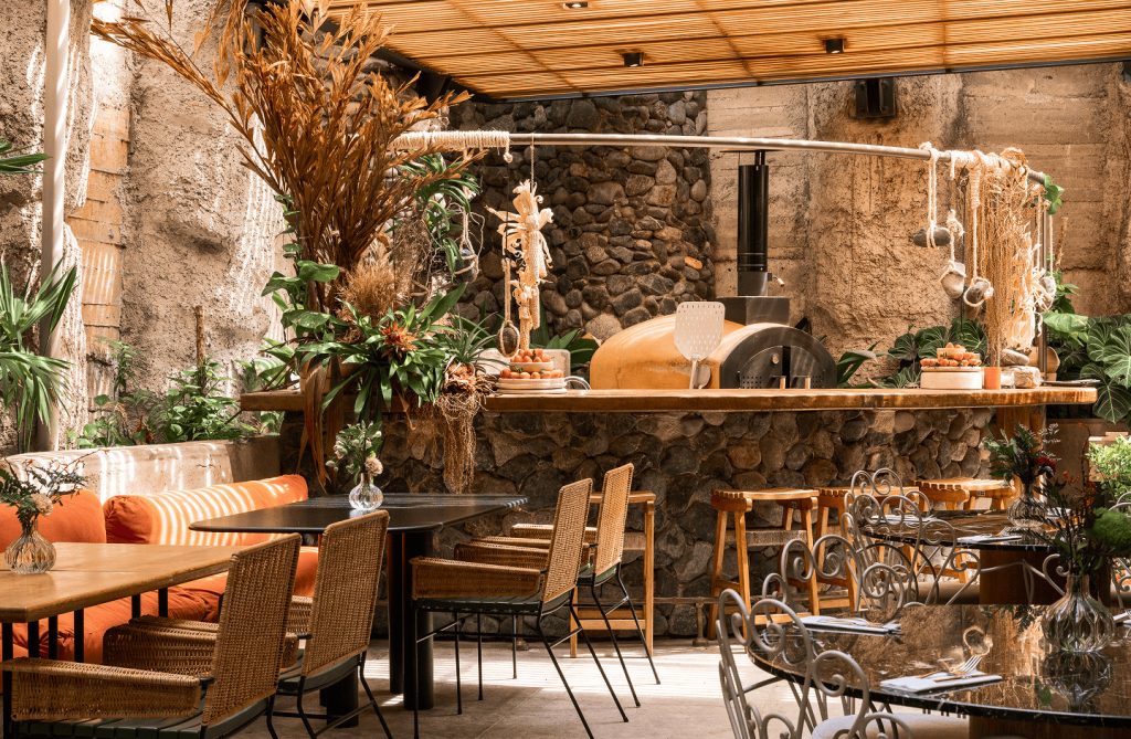 A courtyard restaurant featuring tables and chairs arranged for outdoor dining in a pleasant setting.