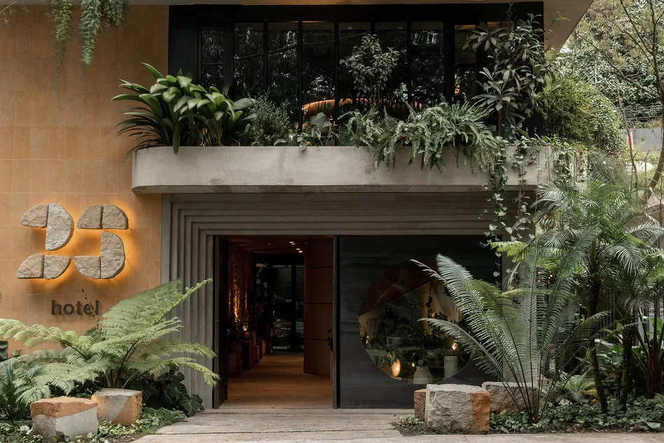 Hotel entrance adorned with lush plants, creating a welcoming atmosphere for guests.