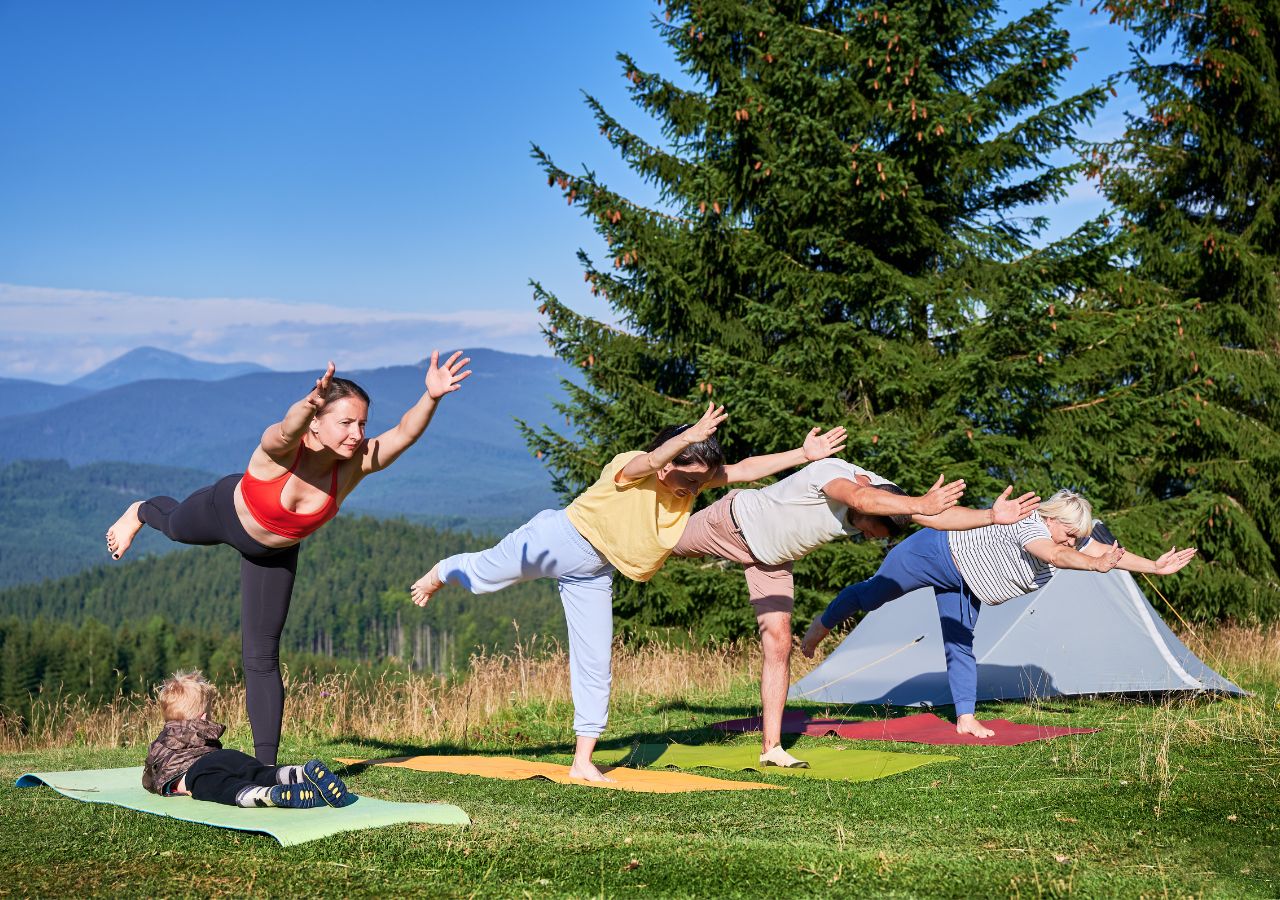 Persona practicando yoga en una montaña, rodeada de un paisaje natural y vistas panorámicas.
