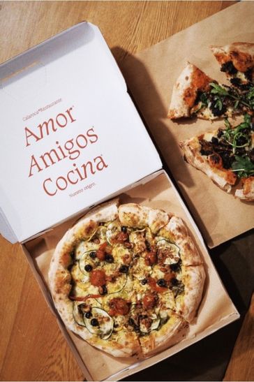 Two pizza boxes: one holds two pizzas, while the other contains one pizza, illustrating a delicious meal selection.