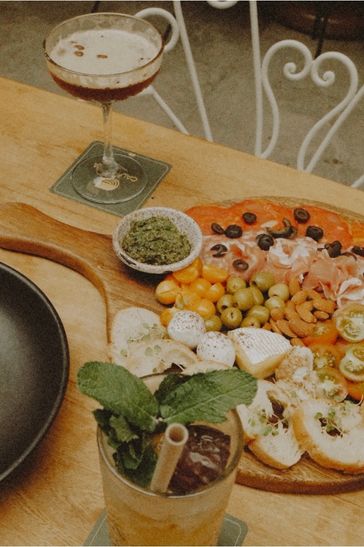A dining table featuring a tray filled with various food items and beverages