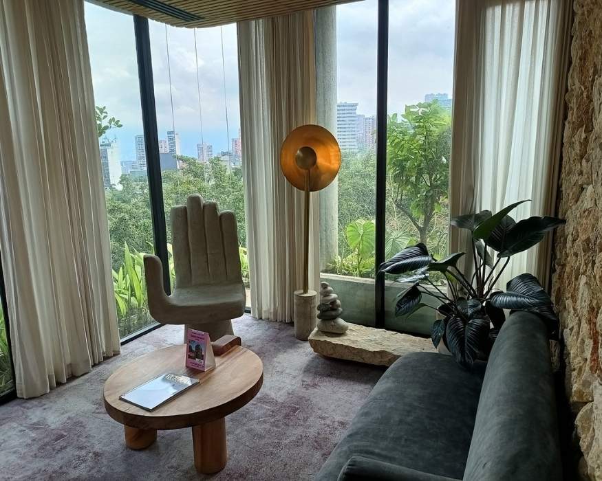 Sala de estar con un sofá, mesa y ventana que da a la ciudad.