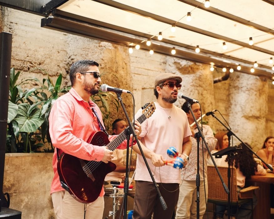 Músicos actuando en un restaurante, ofreciendo entretenimiento en vivo a los comensales presentes.