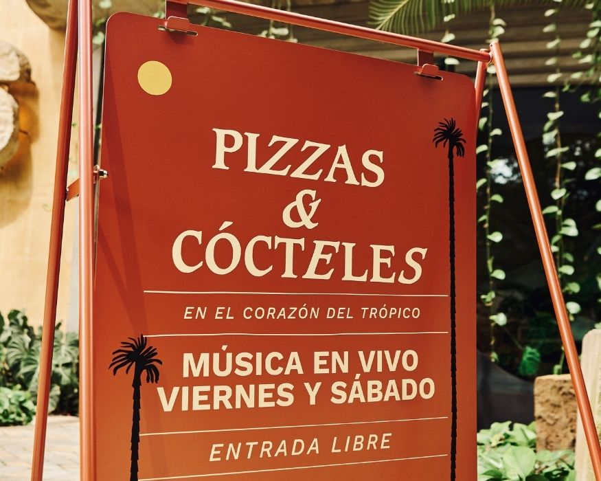 Señal de un restaurante especializado en pizza y cócteles, destacando su oferta gastronómica.