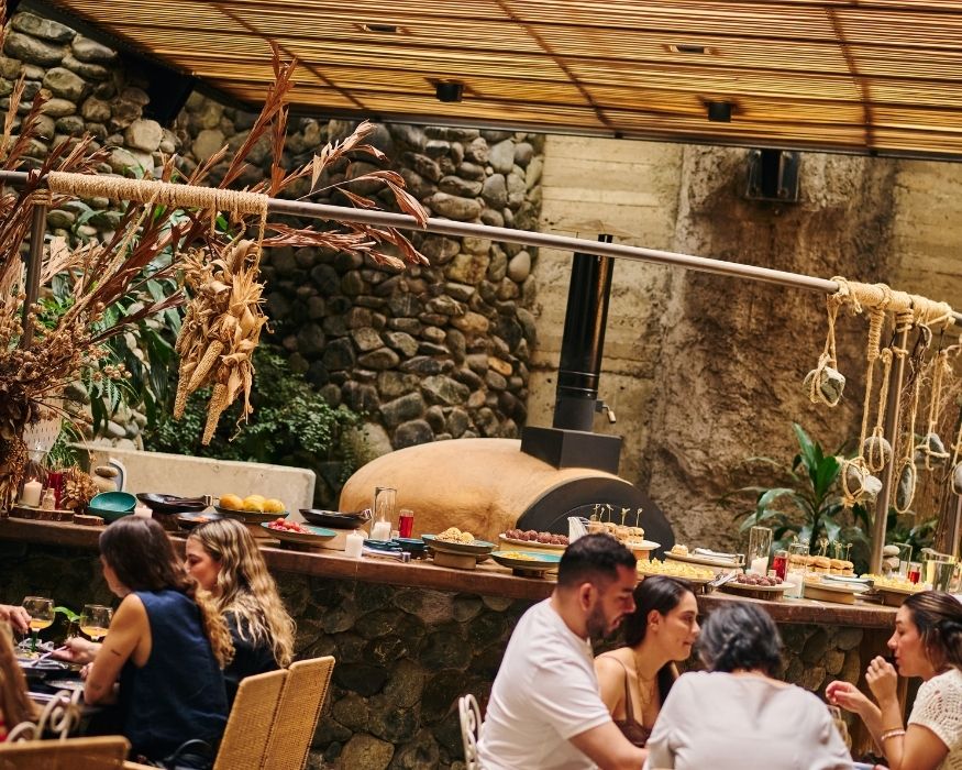 Gente compartiendo una comida en un restaurante ubicado en un edificio de piedra.