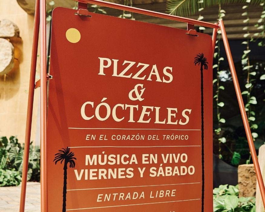 Restaurant sign displaying pizza and cocoteles, designed to attract customers with its colorful and appealing graphics.