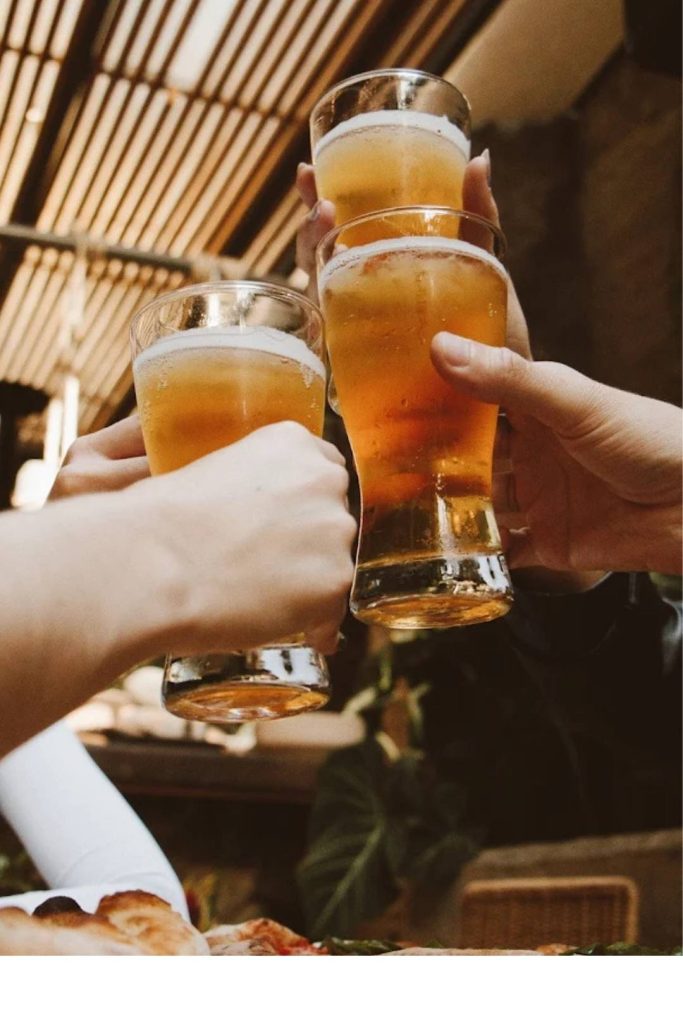 A group of people toasting with glasses of beer, smiling and enjoying a moment together.