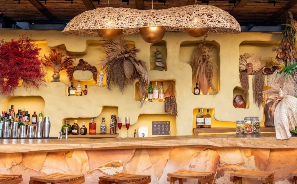 El bar del restaurante de terraza del sol está decorado con diversas plantas que añaden un toque natural al ambiente.