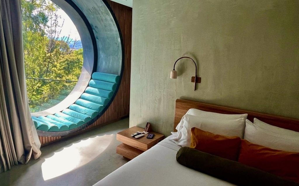 Room pet friendly with a bed and a circular window that provides natural light