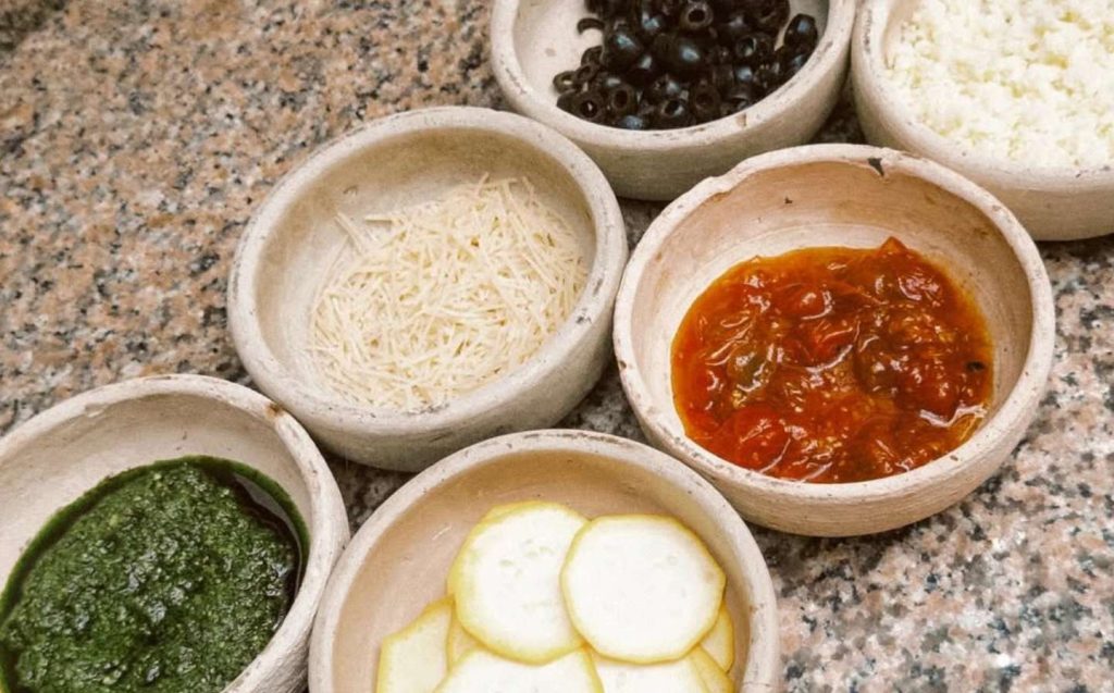 Cuencos con ingredientes frescos listos para preparar una deliciosa pasta en un plato vegano