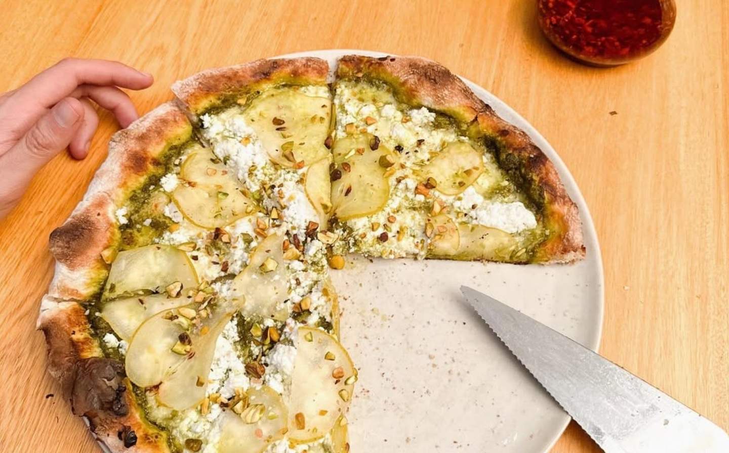 Cheese pizza with green sauce on top, part of the 7-day plant-based pizza option