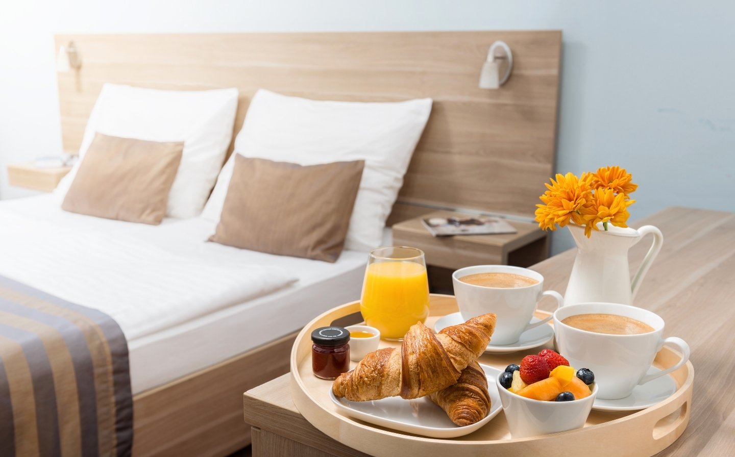 Bandeja con desayuno variado sobre una cama, ideal para disfrutar en un Airbnb o boutique hotel