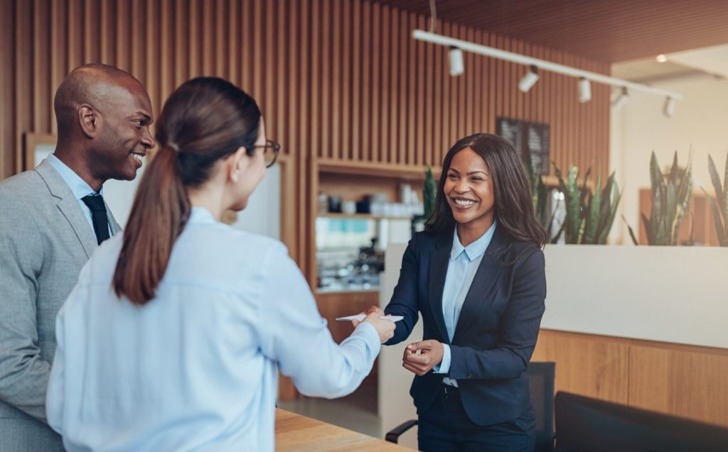 Personas de negocios estrechando manos en una oficina, simbolizando un acuerdo o colaboración profesional