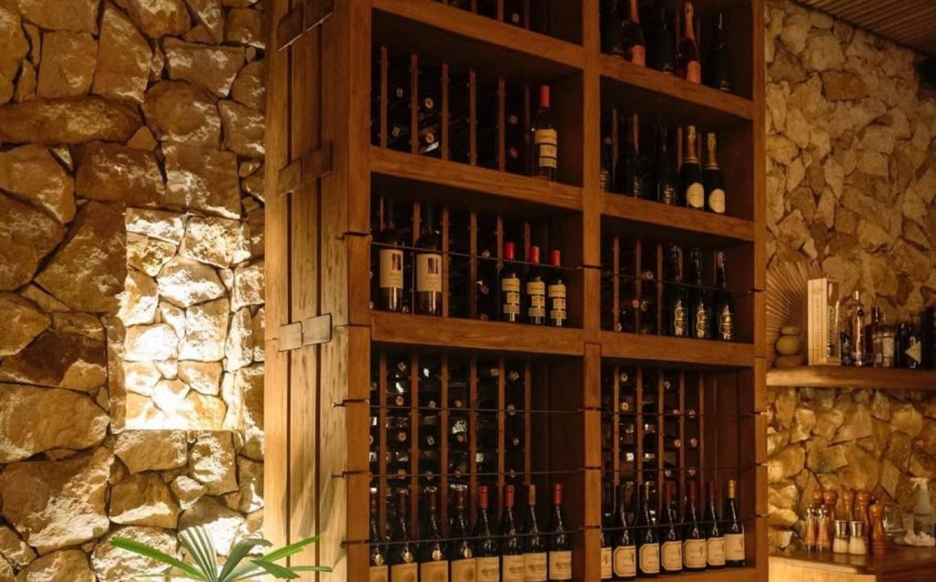 Bodega de vino en el hotel, con estantes llenos de botellas de vino de diversas variedades y colores