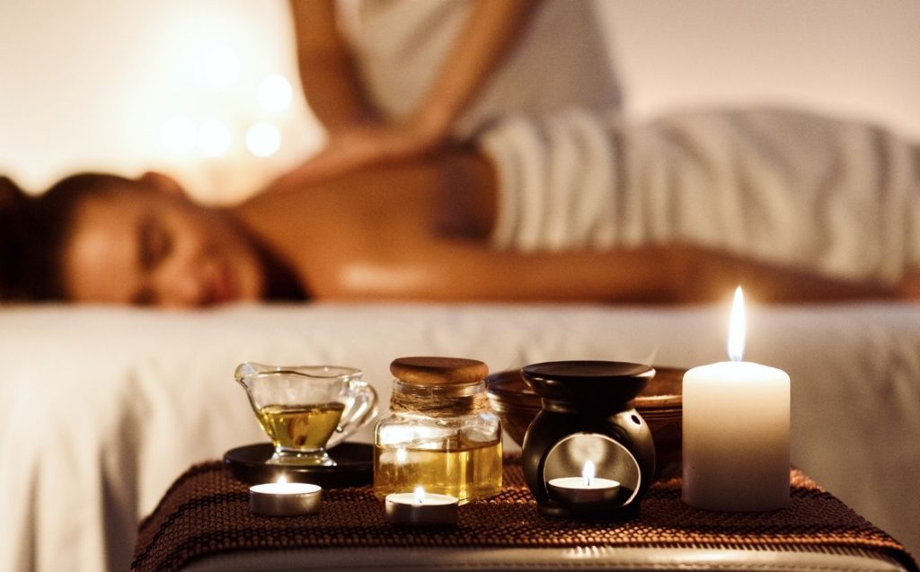 Mujer recibiendo un masaje relajante en un spa, ideal para días lluviosos y momentos de autocuidado.