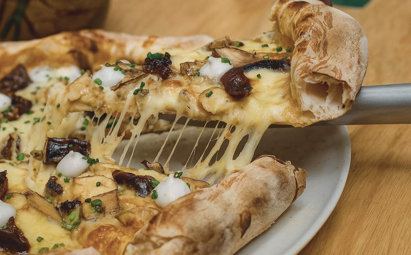 A delicious pizza topped with melted cheese and mushrooms, served on a white plate