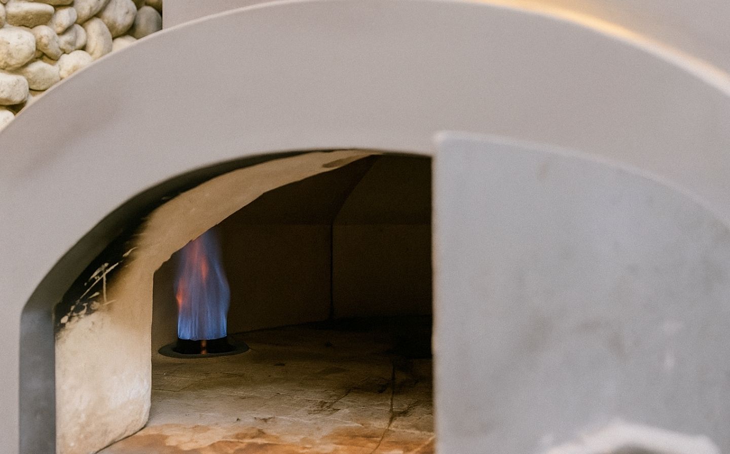 Horno de pizza con fuego ardiente en su interior, listo para cocinar