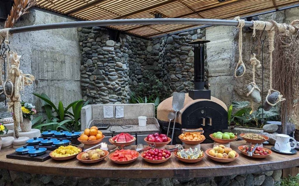 Buffet de frutas y verduras frescas sobre una mesa de madera, ideal para un desayuno familiar en un hotel boutique en Medellín